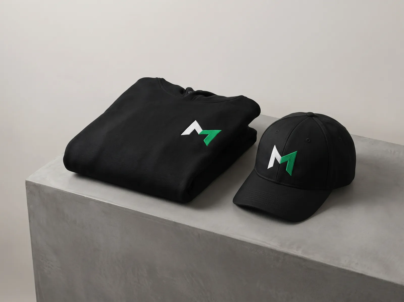 Black hoodie and cap with the Surge M logo